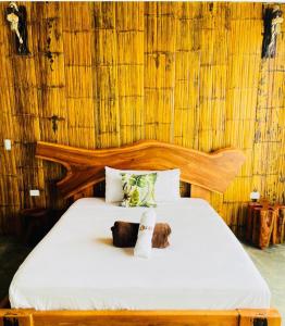 a bedroom with a bed with a wooden headboard at KOFAN Ecohotel in Puerto Asís