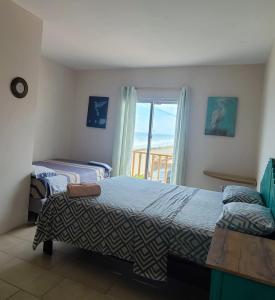a bedroom with two beds and a balcony at Villa Luna frente al mar in Manta