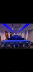 a conference room with a blue table and chairs at The C Hotel in Amnat Charoen