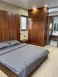 ein Schlafzimmer mit einem großen Bett und einer Holzwand in der Unterkunft Green Bay Luxury Villa Sonasea Vân Đồn 