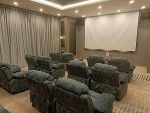 Sala de conferencias con sillas y pantalla de proyector en Cozy Sky Trees, Aeon, Netflix & Pool Views en Johor Bahru