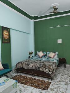 a bedroom with a bed with green walls and a ceiling at Varanasi homestay in Varanasi