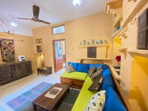 uma sala de estar com um sofá azul e verde em Hamari Haveli em Jaisalmer