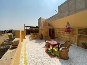 eine Terrasse mit Stühlen und einem Tisch auf einem Gebäude in der Unterkunft Hamari Haveli in Jaisalmer