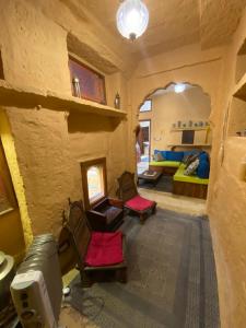 uma sala de estar com duas cadeiras e um sofá em Hamari Haveli em Jaisalmer
