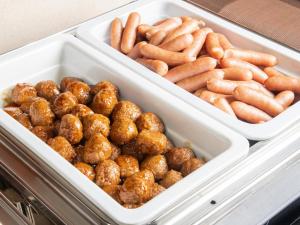 two trays filled with donuts and other food items at Vessel Hotel Fukuyama in Fukuyama