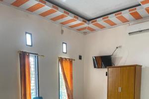 een woonkamer met een koffieplafond en een tv bij OYO 93100 Harapan Homestay Syariah in Parit