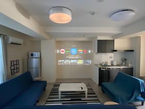 sala de estar con 2 sofás azules y cocina en SuYi, en Osaka