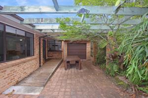 a patio with a wooden bench and a wooden pergola at All Decked Out in Hawks Nest