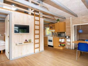 a tiny house with a kitchen and a living room at Holiday home Hovborg XII in Hovborg