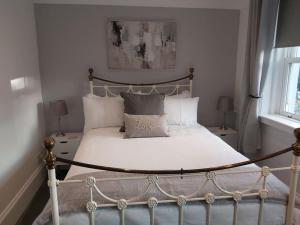 1 dormitorio con 1 cama con sábanas y almohadas blancas en #4 The Quirky Quarters, en Portsmouth