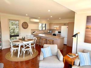 a kitchen and living room with a table and chairs at 'Serenity Now' Shoal Bay Beach Front with All Linen, WiFi and Air Con in Nelson Bay