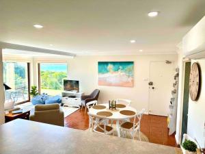 a living room with a table and a couch at 'Serenity Now' Shoal Bay Beach Front with All Linen, WiFi and Air Con in Nelson Bay