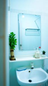 y baño con lavabo blanco y espejo. en Ocean Cottage Maldives en Thulusdhoo