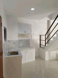 une cuisine avec un évier et un escalier dans l'établissement Unique apartment, à Nsukka
