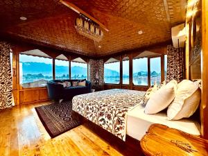 una camera con un letto in una stanza con finestre di New Jacquline Heritage Houseboats a Srinagar