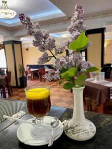 a vase of lilacs and a drink on a table at Срібний Водограй in Polyana