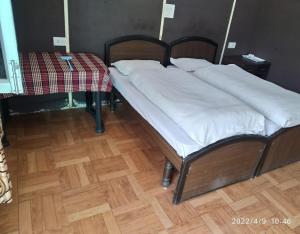 a bed with white pillows on it in a room at Kedar Heights Heli Resorts by StayApart in Phata +2 photos