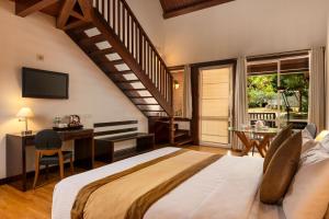 a bedroom with a large bed and a desk and a window at Occidental Paradise Dambulla in Sigiriya