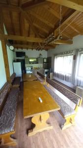 una mesa grande en una habitación con bancos en Къща за гости Ореха, en Apriltsi