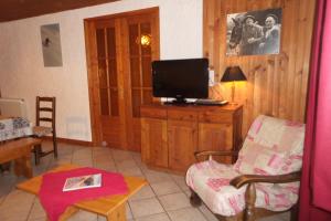 a living room with a television on a wooden cabinet at Chez Bernard & Chantal in Peisey-Nancroix