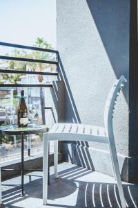 una silla blanca y una mesa con una botella de vino en Jacob Tiberias by Jacob Hotels, en Tiberíades