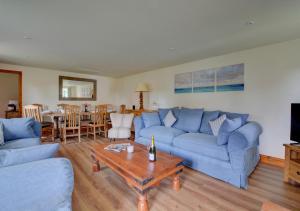 a living room with a blue couch and a table at Finder's Cottage in Docking