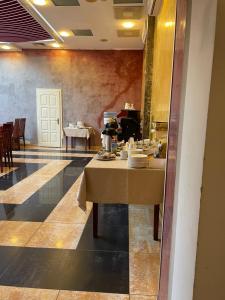uma sala de jantar com uma mesa com pratos em Hotel Sugas em Sfântu Gheorghe