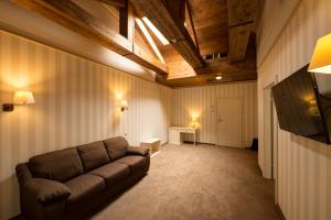 a living room with a couch and a television at Premier Geneva Hotel in Odesa