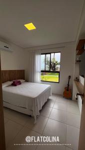 una camera con un letto e una finestra con una chitarra di Flat Eco Resort Praia dos Carneiros @flatcolina a Tamandaré