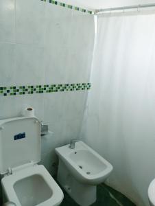 a white bathroom with a toilet and a sink at Tu hospedaje soñado in Durazno
