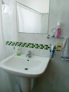 a bathroom with a white sink and a mirror at Tu hospedaje soñado in Durazno