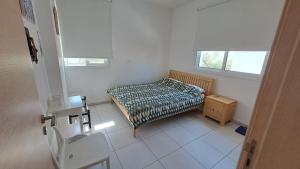 a small bedroom with a bed and a table at Relaxing Avra Villa with Private Pool & Garden Near Protaras in Paralimni +42 photos