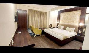 a hotel room with a bed and a desk at FabHotel Prime Garden View in Jaipur