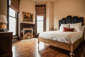 Un dormitorio con una cama grande y una chimenea. en Henrie House I Luxury 4BR Downtown Historic Gem with Library & Patio, en Nashville