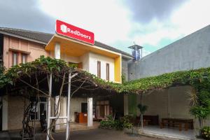 a building with a red sign on top of it at RedDoorz Syariah near Pakuwon Mall Jogja in Kejayan
