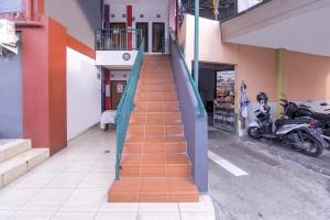 uma escada que leva a um edifício com uma moto em OYO 3317 Maju Jaya Homestay Syariah em Bogor