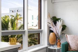 a room with two windows and a green chair at Ray's Place by the Riverside in Glenelg
