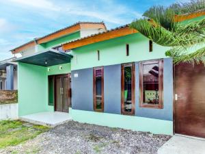 una casa verde y azul con puerta marrón en SPOT ON 92490 Casa Homestay Syariah, en Brangsong