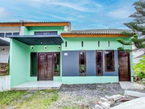 uma pequena casa com um verde e azul em SPOT ON 92490 Casa Homestay Syariah em Brangsong