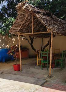 - un abri en bois avec des chaises et une table dans la cour dans l'établissement appartement Villa Nancy, à Toamasina