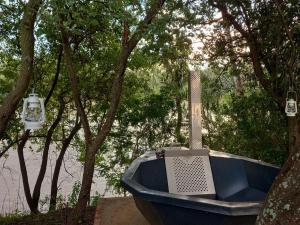 a blue boat sitting next to a tree at FLY FISHING PARADISE ON THE VAAL in Parys