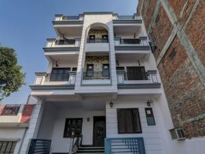 ein hohes weißes Gebäude mit Balkonen darauf in der Unterkunft Collection O Hotel The Lemongrass in Allahabad