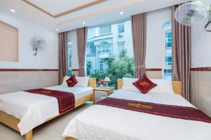 2 Betten in einem Zimmer mit Fenster in der Unterkunft Thịnh Anh Hotel in Vũng Tàu