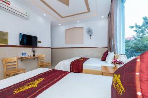 ein Hotelzimmer mit 2 Betten und einem Schreibtisch in der Unterkunft Thịnh Anh Hotel in Vũng Tàu