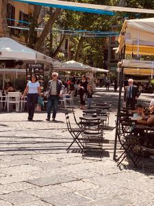 un grupo de personas caminando por una calle con sillas y mesas en MAISON LILLY, en Nápoles