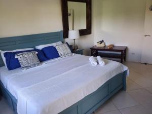 a large blue bed with two white towels on it at St James. Lantana 36 . Beautiful 2 bed apartment in Saint James