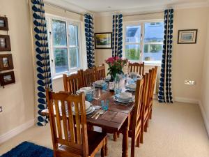 a dining room with a wooden table and chairs at 3 Strawberry Close in Little Haven