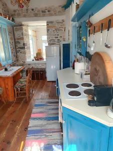 a kitchen with blue cabinets and a white stove top oven at Kokkari Traditional House in Kokkari