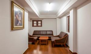 a waiting room with a leather couch and chairs at Treebo Trend Akshaya Residency in Bangalore